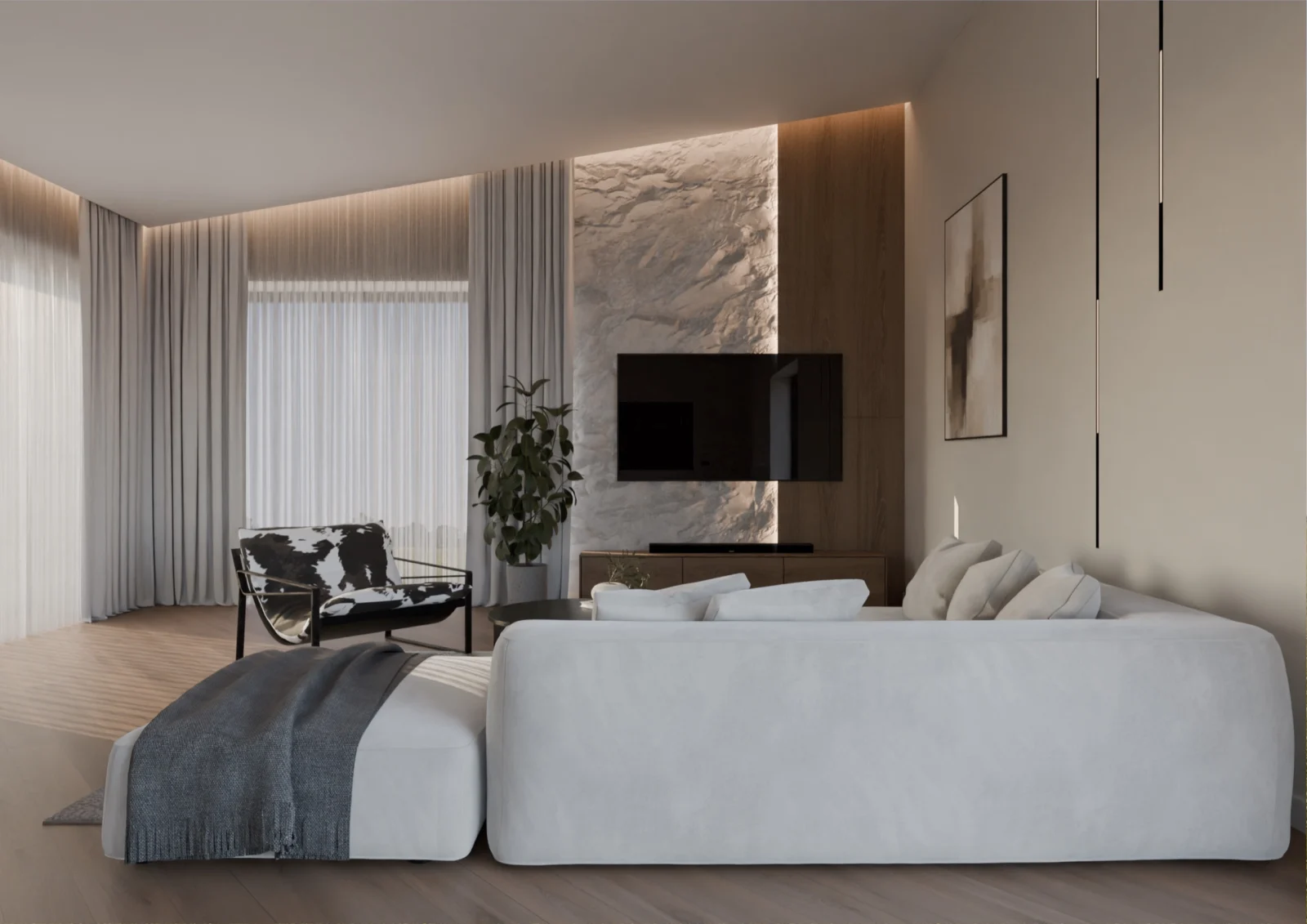 Svetainė su didele šviesia sofa, akmens plokšte už televizoriaus ir šilta šviesa