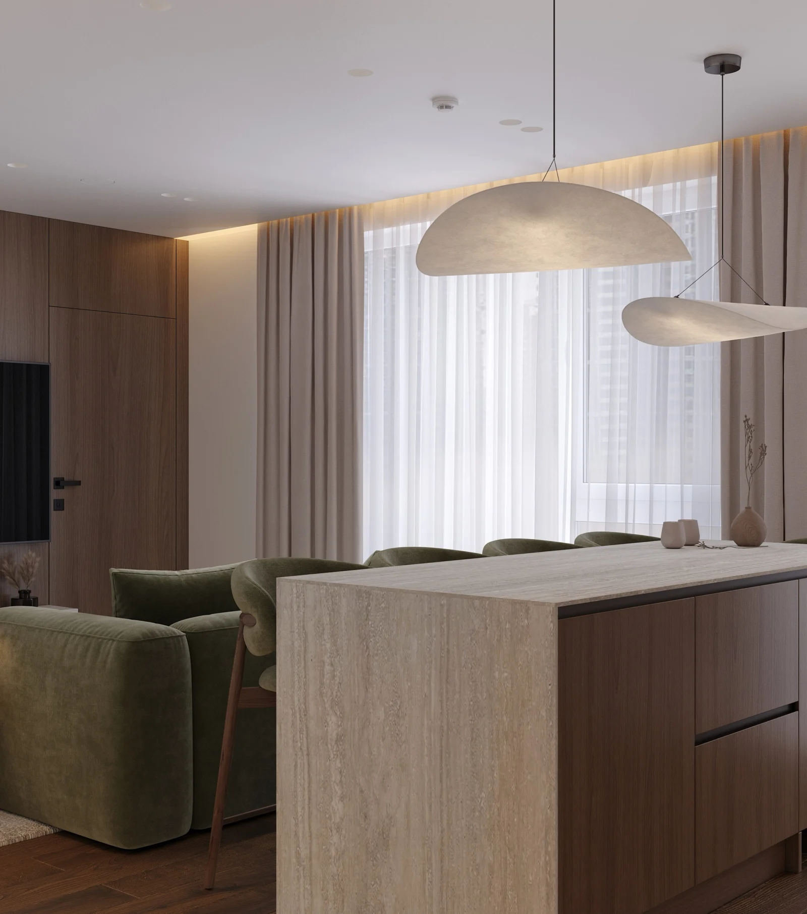 Virtuvės sala su travertino stalviršiu, kabančiais šviestuvais ir žalia sofa fone